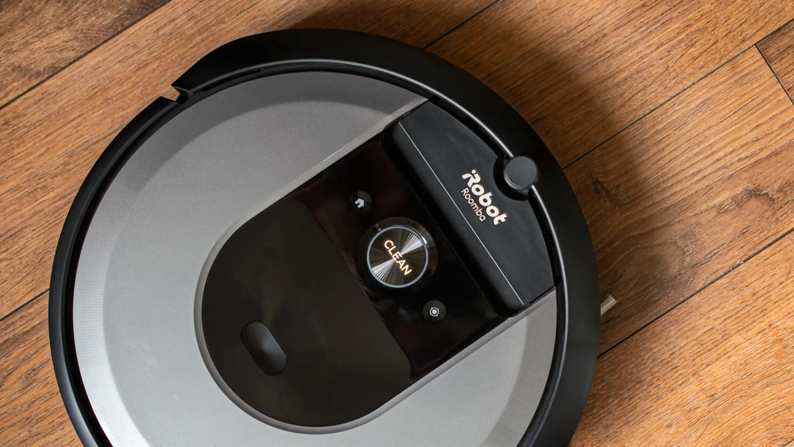 Roomba robot vacuum on hardwood floor.