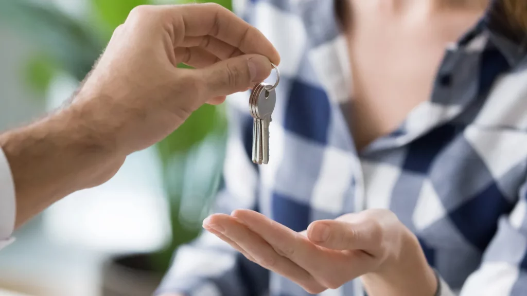 Young woman getting keys to new apartment from realtor