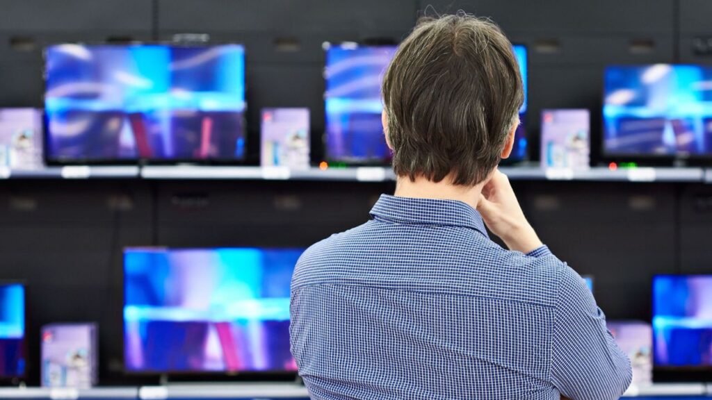 Person watching TVs in a store.