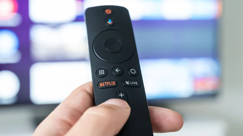 a man holds a remote control in his hand with