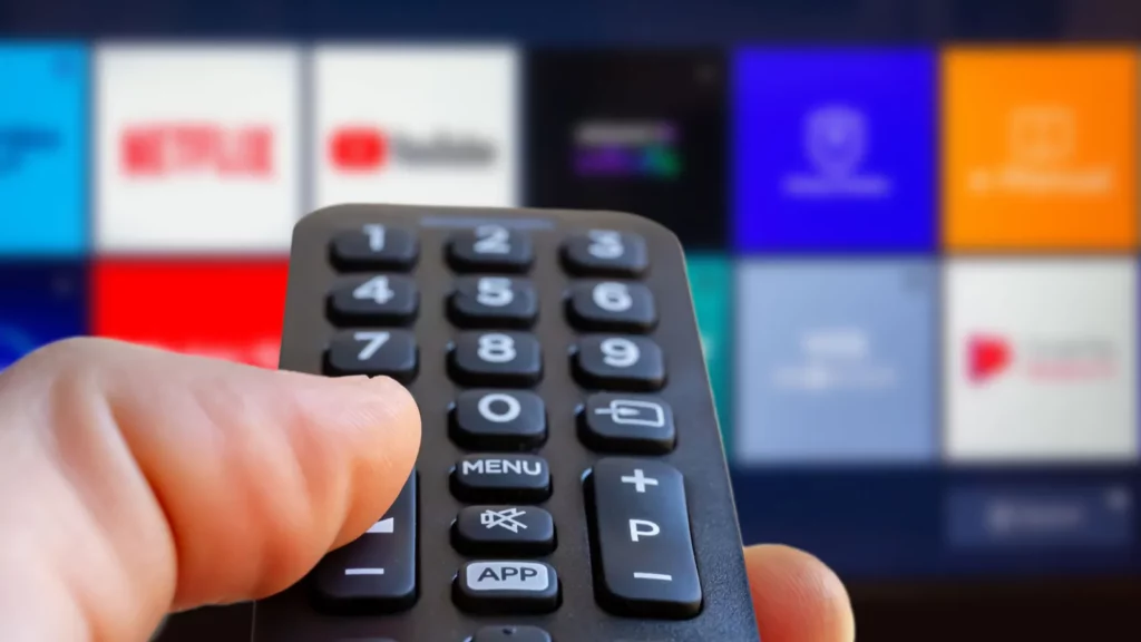 a man is holding the remote control of a smart