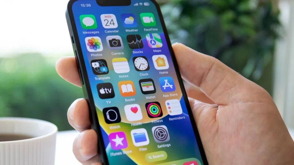 Vyras, laikantis „iPhone“ su keliomis programomis