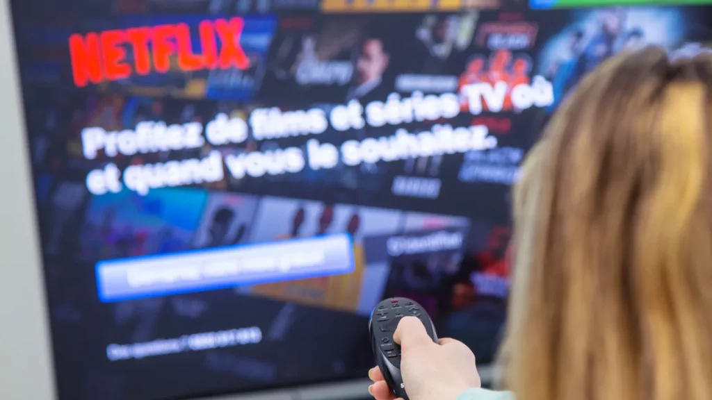 woman holding a tv remote control and switching channels on