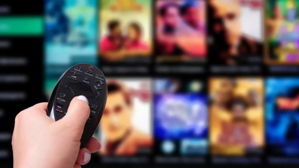 A man using remote to control the TV.