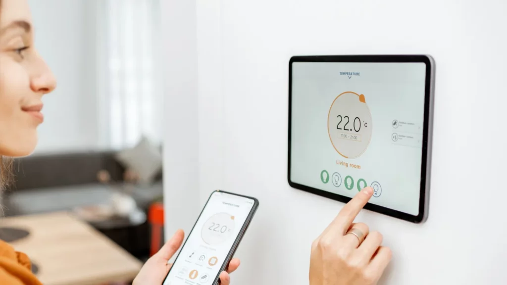 A woman controlling temperature using smart thermostat.