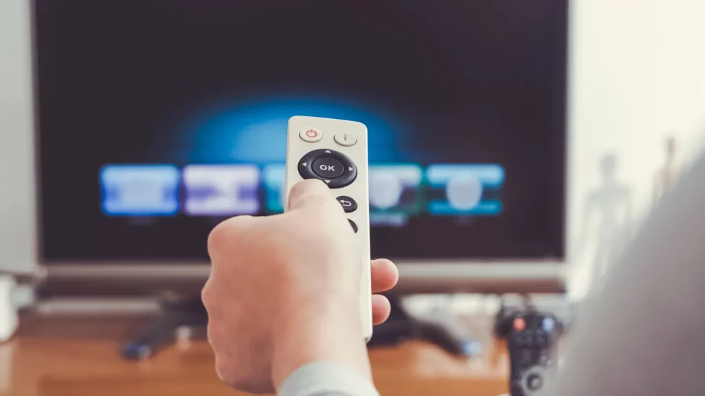 A woman holding remote control of TV.