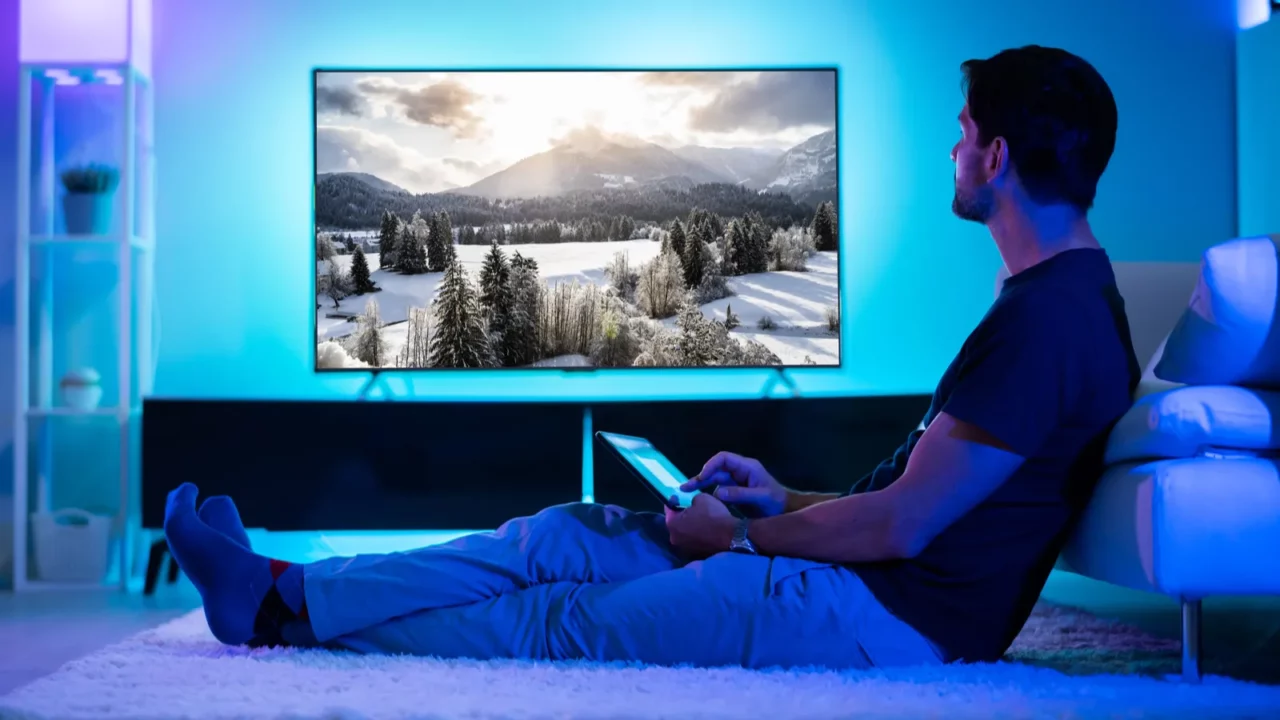 A man streaming movie on TV.