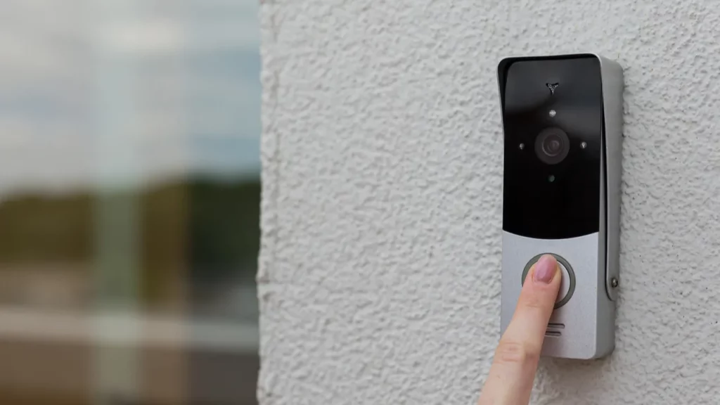 A woman pressing on doorbell camera's button.