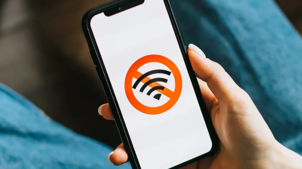 Hands holding smartphone with no internet or wifi sign at