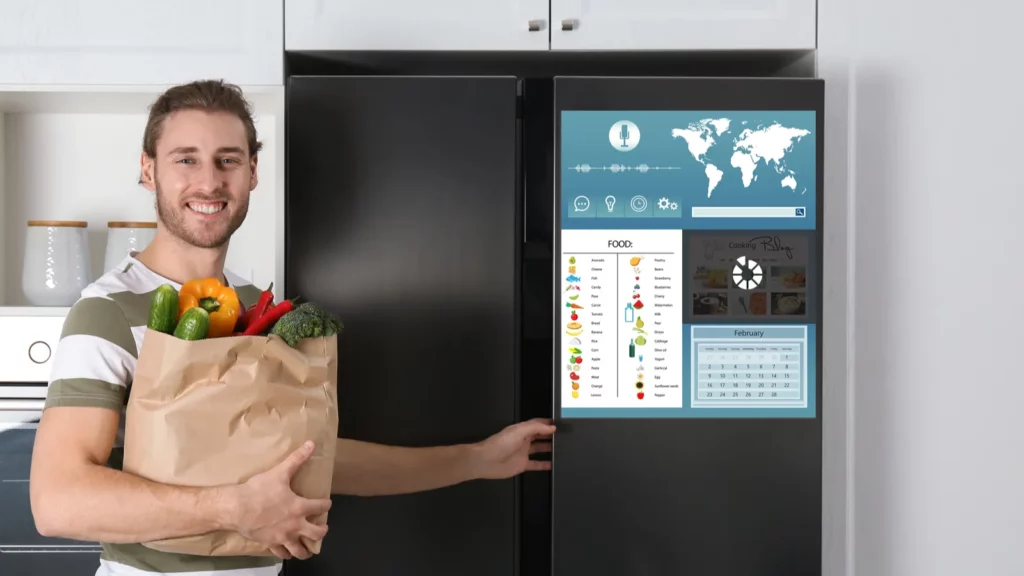 A young man controlling smart refrigerator with touchscreen,