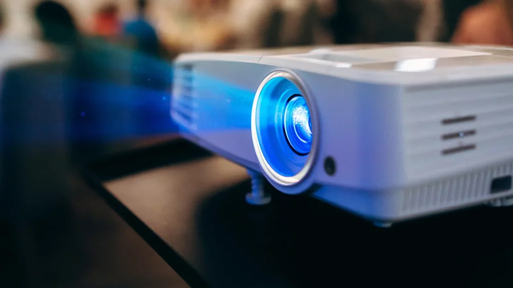 White projector emitting blue light beam indoors.