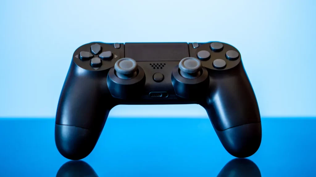 Black game controller on blue background.