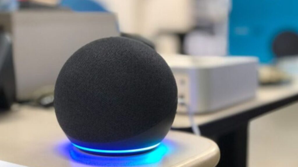 Black smart speaker with blue light ring.