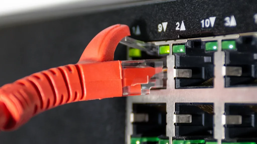 Raudonas Ethernet kabelis jungiklio prievade.