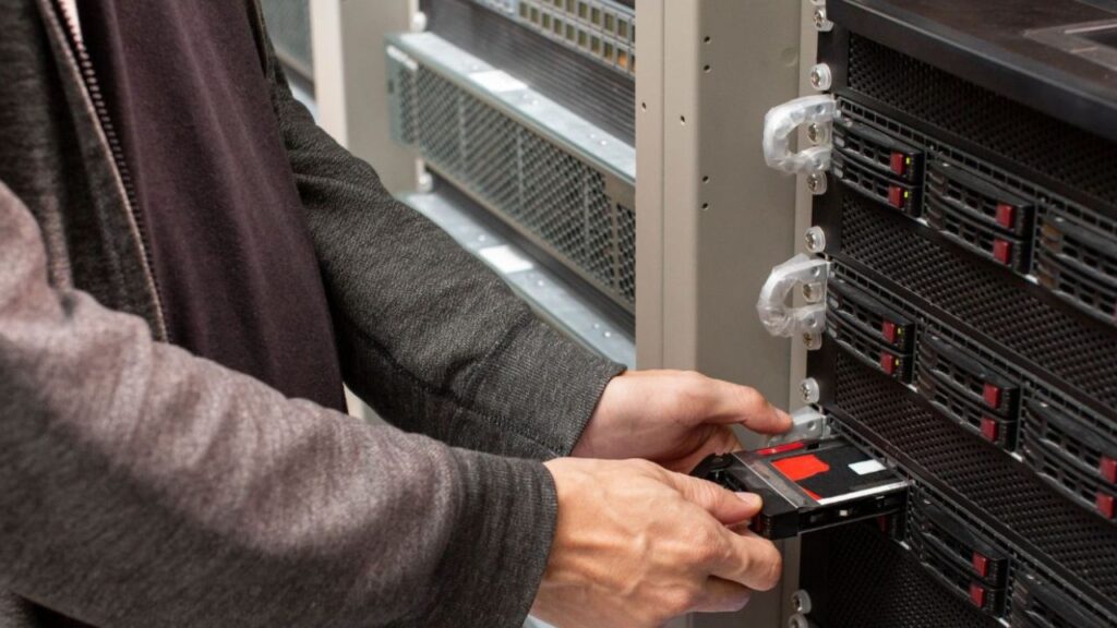 Asmuo, montuojantis serverį stove.