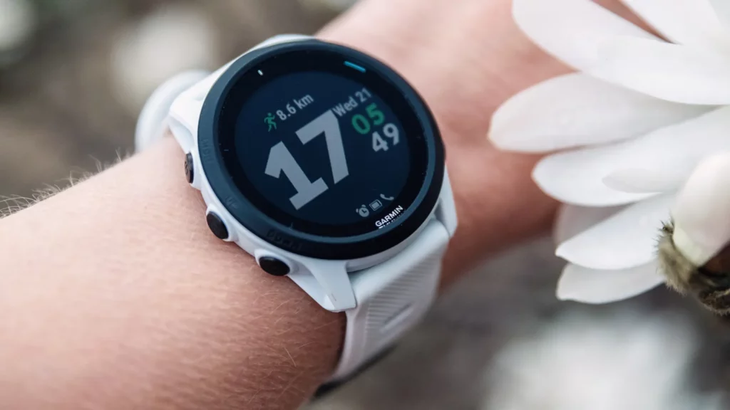 White smartwatch showing time and fitness stats.